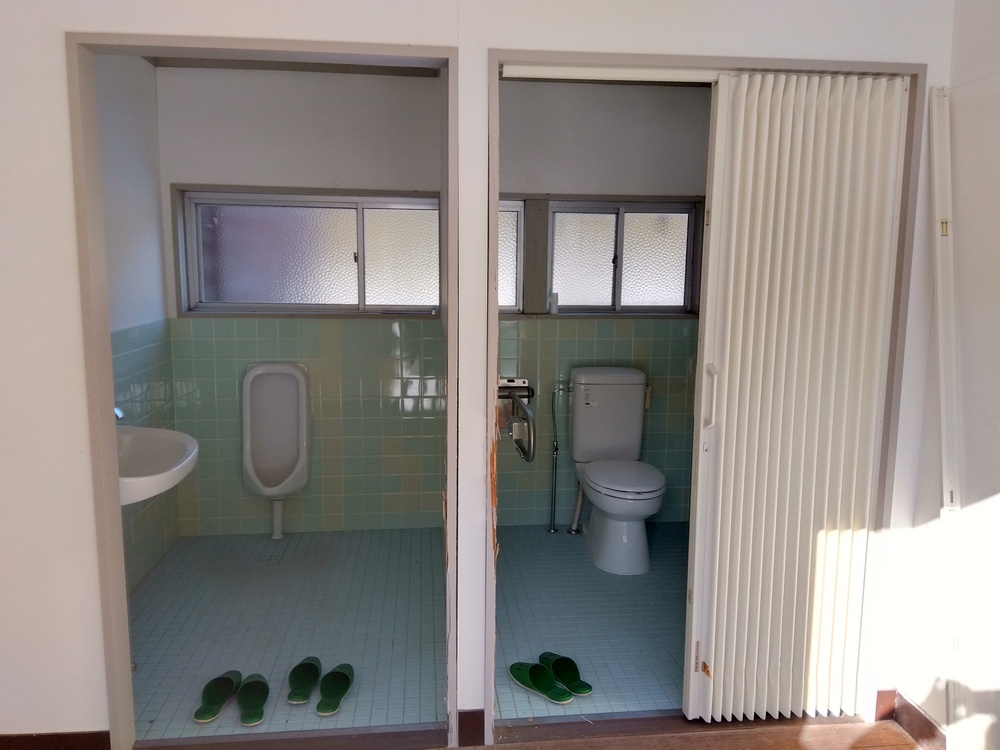 【鳥取県日野町】公民館トイレ入口改修工事｜老朽化した施設を安全で快適な空間へ改修前トイレドア正面ビフォー